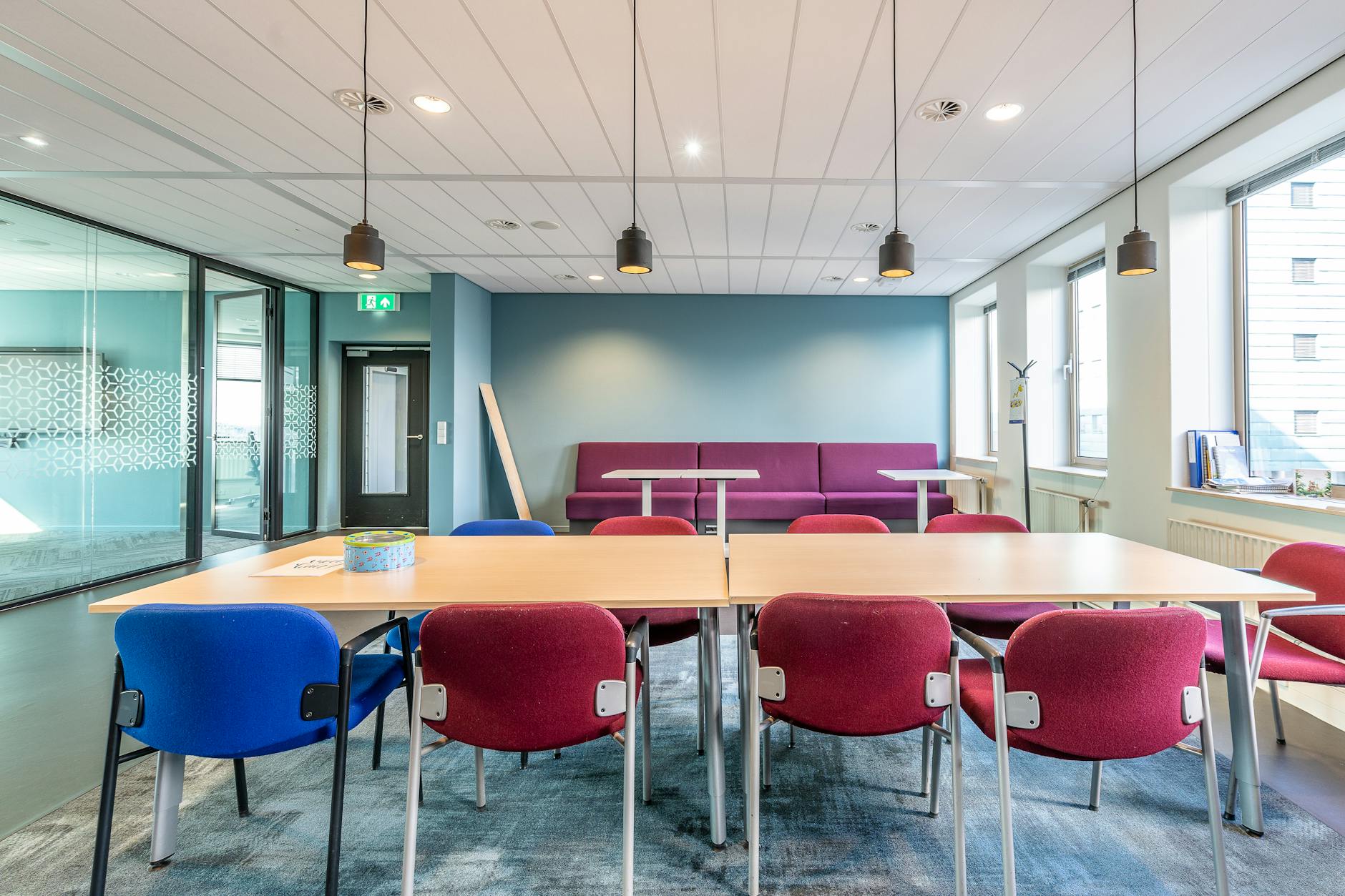 Contemporary office interior with colorful chairs and ample natural light.